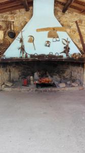 a large stone fireplace with a fire in it at Agriturismo Su Pinnettu in Fonni