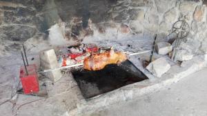 ein Huhn auf einem Stock, das in einem Backsteinofen kocht in der Unterkunft Agriturismo Su Pinnettu in Fonni