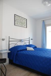 a bedroom with a blue bed and a table and a window at Casa Fanny in Limone sul Garda