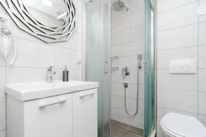 a white bathroom with a sink and a shower at Apartments Shining Star in Dubrovnik +26 photos