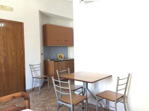 a kitchen and dining room with a table and chairs at Jazoj Family hotel in Orikum