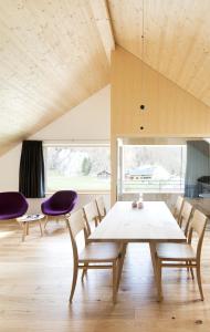 a dining room with a white table and purple chairs at Hotel Tannahof in Au im Bregenzerwald