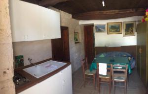 a kitchen with a sink and a table in a room at Trullo Malvisco in Alberobello