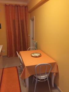 una mesa de comedor con sillas y un plato. en Berenice en Taranto
