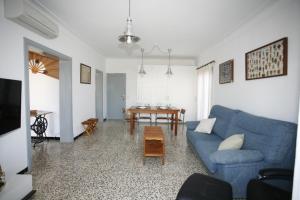 ein Wohnzimmer mit einem blauen Sofa und einem Tisch in der Unterkunft Lola in Sa Ràpita