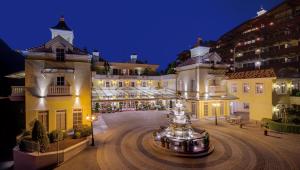duży budynek z fontanną przed nim w obiekcie Wellnessresidenz Alpenrose w mieście Maurach