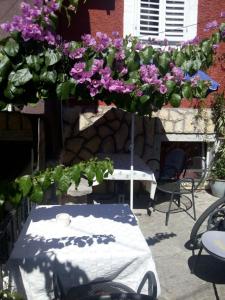 a table with purple flowers on top of it at Apartman i Sobe Čule Cres in Cres