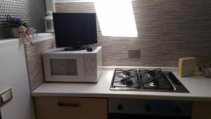 マレスコにあるAppartamento Maury Locazione Turisticaの電子レンジ、テレビが備わるキッチンカウンター