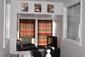 a living room with two chairs and a television at The Spaniards Room Heritage Home in Spaniards Bay