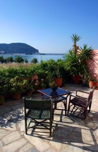 a patio with two chairs and a table with a view of the water at Spitalia Studios in Skopelos Town
