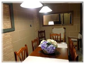 a dining room table with a basket of flowers on it at Casa Rural Estrela in San Martín de Trevejo