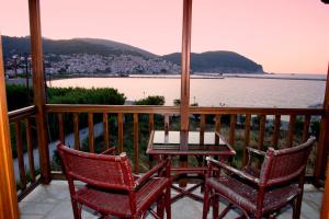 two chairs and a table on a balcony with a view of the water at Spitalia Studios in Skopelos Town +4 photos