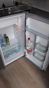 an open refrigerator filled with food and water at Happy Plaine in Sainte-Croix-en-Plaine