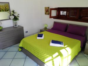 um quarto com uma cama verde e toalhas em Villa Modus Vivendi em Cinisi
