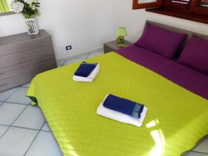 a bedroom with a green bed with towels on it at Villa Modus Vivendi in Cinisi