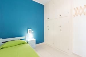 a blue bedroom with a bed and a blue wall at Panorama Apartments updated with infinity pool in Agios Nikolaos