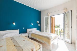 two beds in a room with blue walls at Panorama Apartments updated with infinity pool in Agios Nikolaos