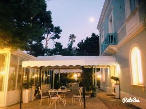 a patio with a table and chairs in front of a building at Villa Arlini in Pineto