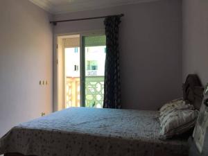 a bedroom with a bed and a door with a window at Al Kawtar in Mohammedia +14 photos