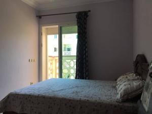 a bedroom with a bed and a door with a window at Al Kawtar in Mohammedia