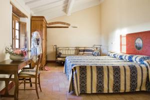1 dormitorio con 2 camas, mesa y escritorio en Poderi Arcangelo, en San Gimignano
