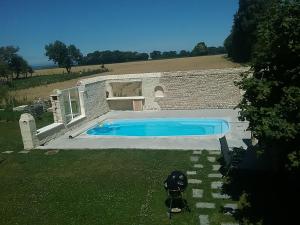 a swimming pool in a yard next to a building at Cottage B2 Bazenville in Bazenville