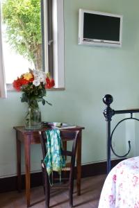 a vase of flowers on a table next to a window at Poderi Arcangelo in San Gimignano