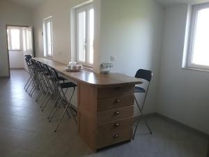 a room with a wooden table with chairs and windows at Cottage B2 Bazenville in Bazenville +15 photos