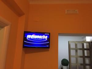 Un televisor en una pared con un cartel azul. en Berenice, en Taranto