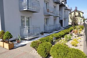 an apartment building with a garden of plants at Solar Bed & Breakfast in Karwia