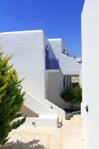 a white building with a blue balcony at Hotel Anatolia in Ano Mera