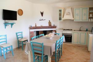 a kitchen with a table and chairs and a stove at Casa del Cervo in Ingurtosu