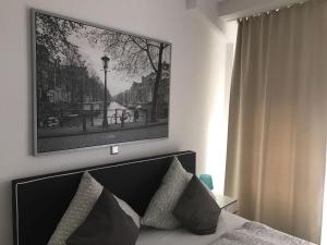 a bedroom with a bed with a picture on the wall at Balthasar Neumann Speiserei & Gästehaus - Zentrum Brühl - in Brühl