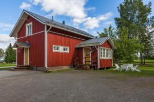 a red barn with a table and chairs in front of it at Erkin Haussi in Ilmajoki