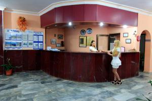 a woman standing at the counter of a pharmacy at Bariscan Hotel in Mahmutlar