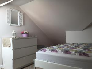 カルビアにあるApartamenty Balticのベッドルーム1室(ベッド1台、鏡付きドレッサー付)