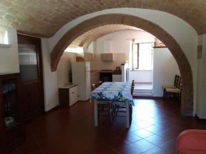 eine Küche und ein Esszimmer mit einem Tisch in einem Torbogen in der Unterkunft Affittacamere Antonio e Francesca in Staggia