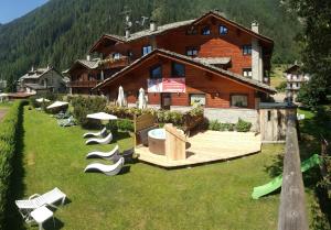 a house with a bunch of chairs in the yard at Residence Ruetoreif in Gressoney-Saint-Jean