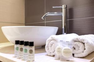 un bagno con lavandino e 4 bottiglie di sapone di Memories Beach Hotel a Monolithos