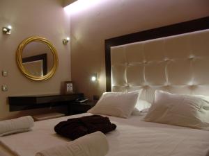a bedroom with a large white bed with a mirror at Ellinis Hotel in Chania
