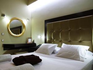 a bedroom with a large white bed and a mirror at Ellinis Hotel in Chania Town
