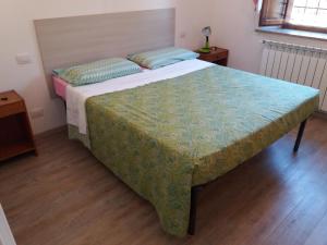 StaggiaにあるAffittacamere Antonio e Francescaのベッドルーム1室(緑色のベッドカバー付きの大型ベッド1台付)