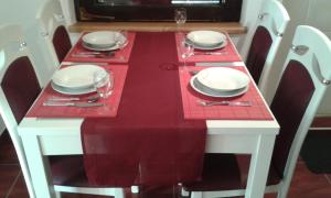 a red and white table with plates and wine glasses at Apartman Potocki in Krapina