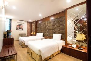 a hotel room with two beds and a window at Canary Ha Noi Hotel in Hanoi