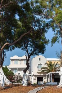 a white building with trees in front of it at Memories Beach Hotel in Monolithos