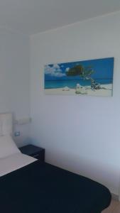 una camera con un letto e una foto appesa al muro di B&B Linus a La Spezia