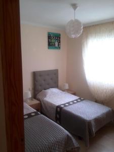 a small bedroom with two beds and a window at Apartament Costa Rica 2 in Benidorm