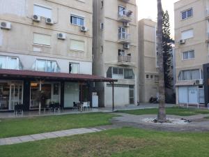 een appartementencomplex met een boom ervoor bij Billis Beach Apartment in Limassol