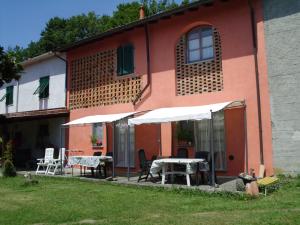 une maison avec une table et des chaises à l'extérieur dans l'établissement Agriturismo Cà Rossano, à Licciana Nardi