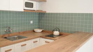 a kitchen with a sink and a microwave at Aparthotel Fleming 50 - Adults Only in San Antonio +32 photos